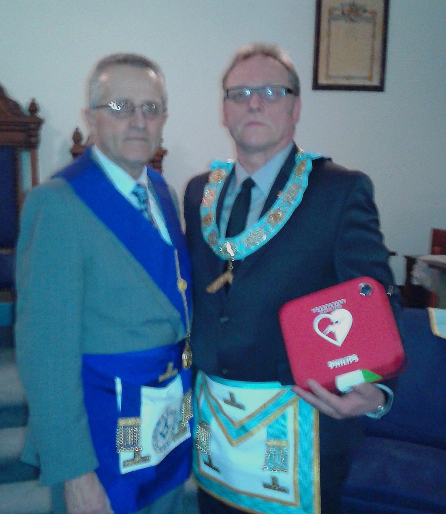 "R.W. Bro Paul Astles, on behalf of W. Bro. Chris Astles, presented W. Bro. Bernhard Weisner on February 8, 2016 with an Automated Defibillator for use in Penewobikong Lodge No. 487. This unit was donated by Cameco Corporation. Chris Astles, a Past Master of the Lodge is the Plant Manager".